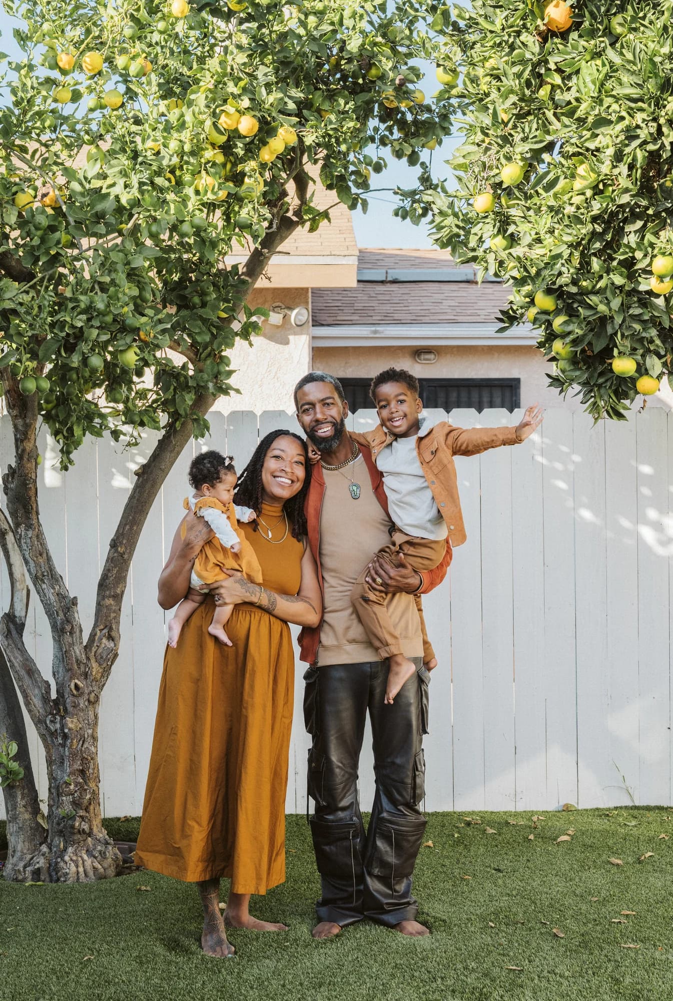 Malcolm Harvest Jr. with family beneath fruit-bearing trees